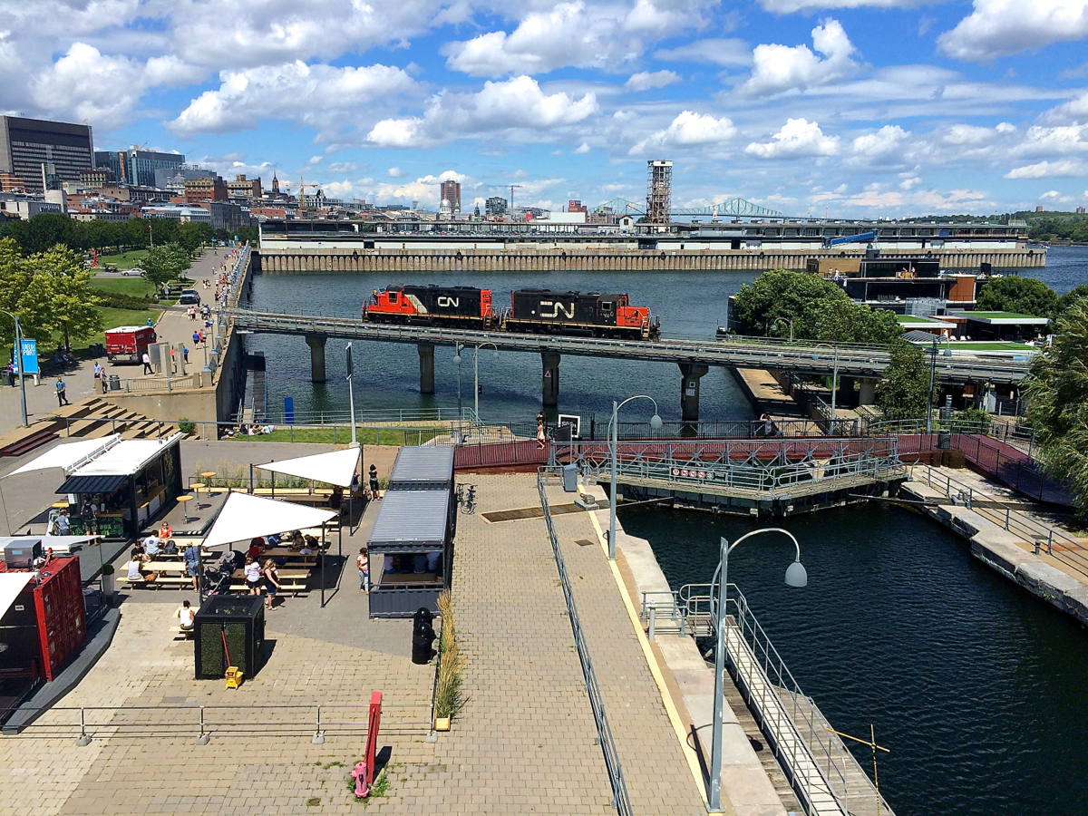A pair of GP9's (CN 7083 & CN 7020) head light over the eastern end of the Lachine canal in old Montreal.