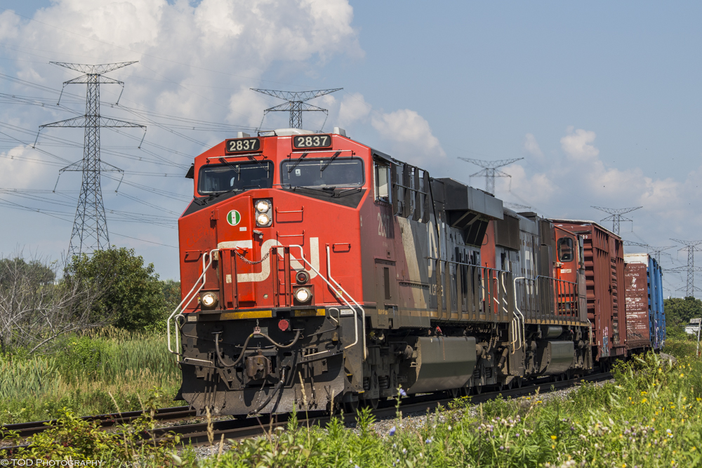 A massive westbound mixed freight, CN M369 comes through Bowmanville with double mid DPUs- CN 2036 and CN 2938