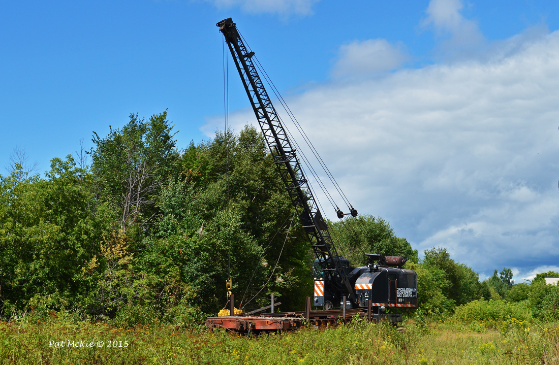 Ottawa Valley Railway Crane sits outside of the North Bay yard as they work between the yard and Mile 1 on the Cartier sub. He we see the OVR-American crane Picking up old rail along the side of the track and loading on to flat car RLK 300001.