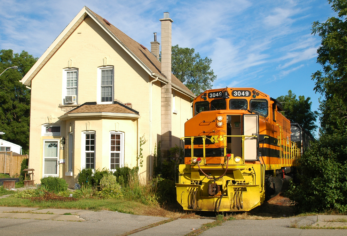 RLHH 3049 passing between #10 and #12 Port Street on the way to Ingenia with six hoppers
