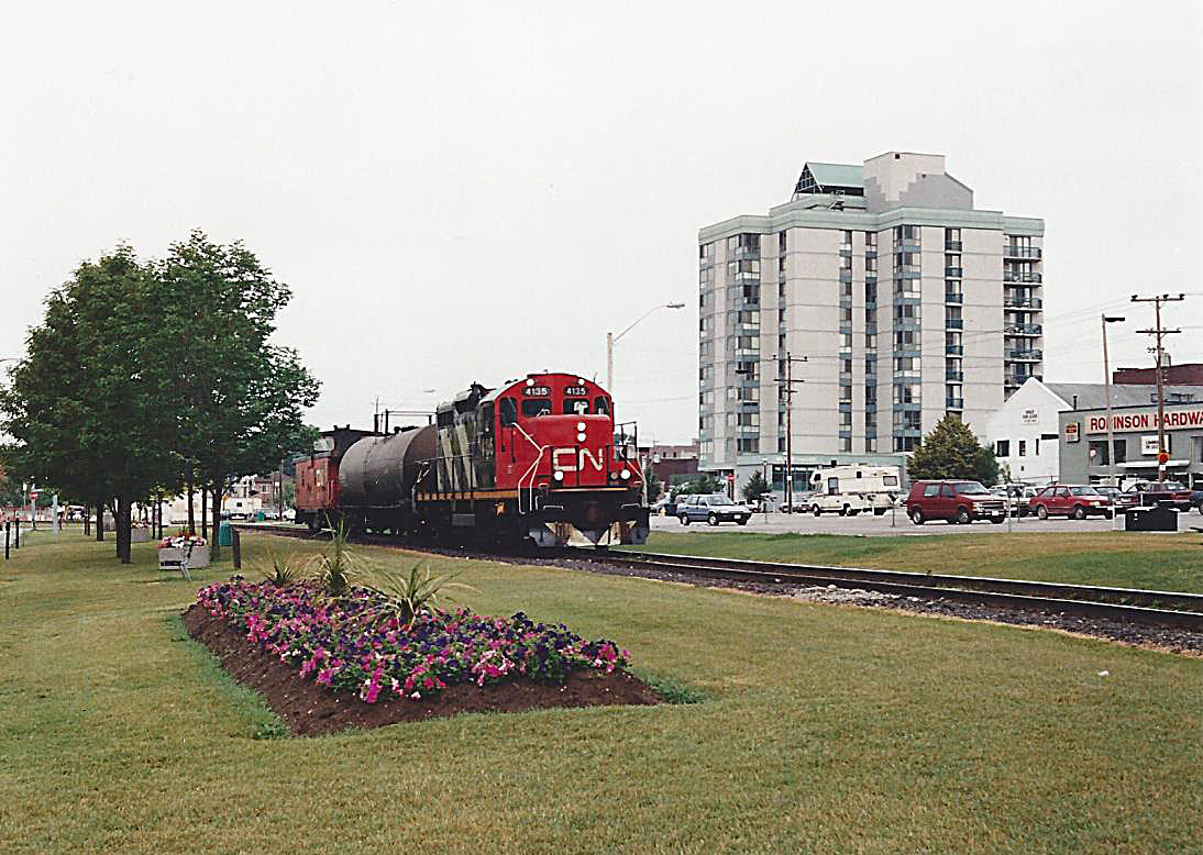 N 4135 has just crossed Bayfield Street with a single tank car bound for Stepan Canada in Longford Mills. This portion of the Newmarket Sub was lifted in 1996. Longford Mills is now serviced out of Huntsville and Wayne Shaw gets to take photos of it. One nice thing about the Newmarket Sub wrapping around Kempenfelt Bay was that if you heard a train you usually had time to get to a place to see it. My Blue 86 Honda Civic is to the right of the train, so I must have made a quick trip from the office. With the exception of the condo building, everything has changed.