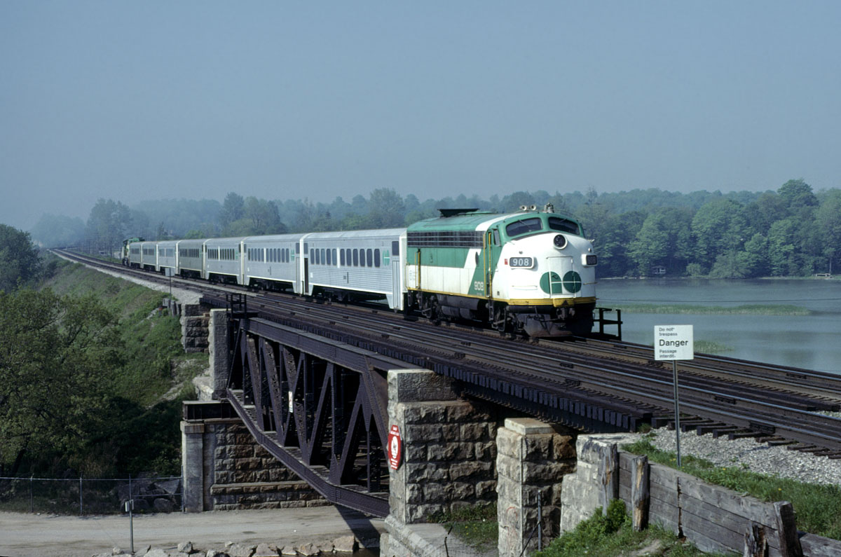 GO Transit #908 formerly Ontario Northland #1514 leading an eastbound commuter across the Rouge River east of Toronto on the beautiful spring morning of May 28, 1978