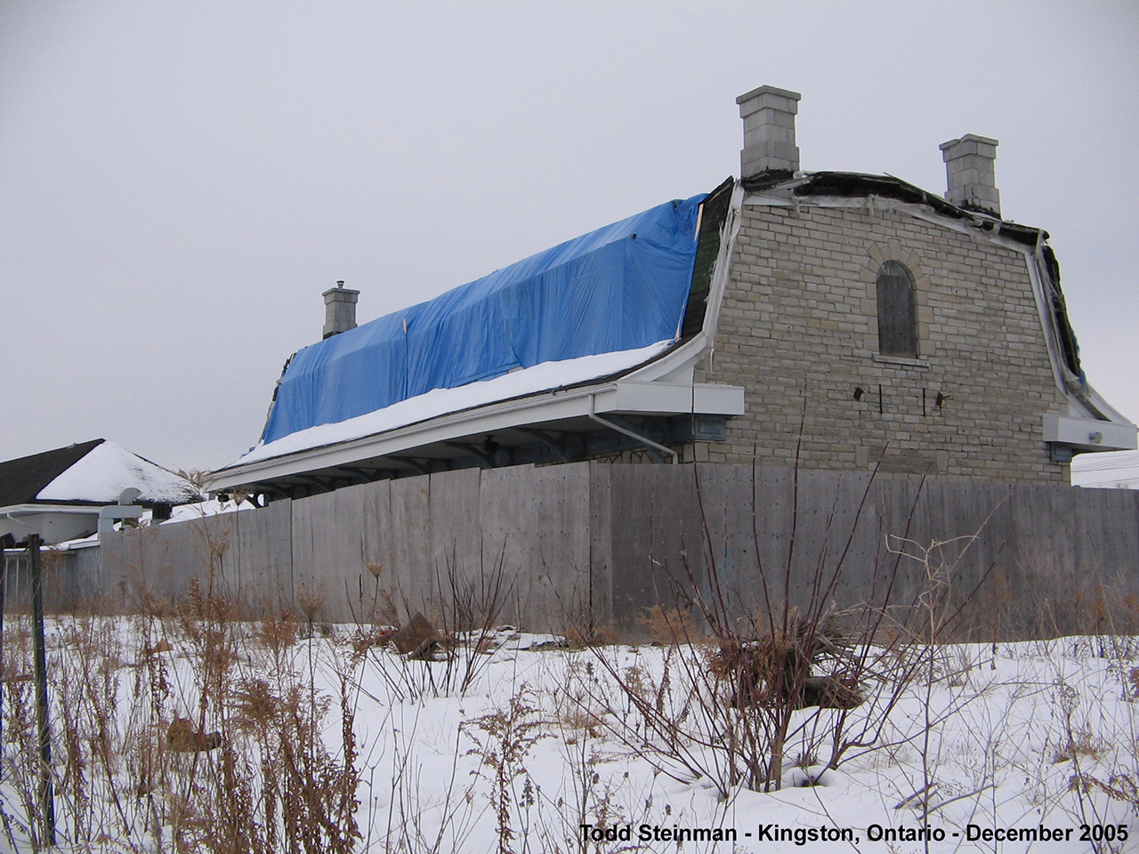 Ex-GTR / CN "Outer" Station located on Montreal Street in Kingston, Ontario. It was in rough shape when I took this photo in 2006....and it hasn't improved. The roof was removed a little later, as the station had been previously damaged by a fire some years before. 

It was with hope that something would be done with this station, and that CN would build a new roof. Political and other aspirations apparently won the day, and a new roof has not been built. Last I had known when passing this station again in mid-2013 - the walls of the structure were held up with wooden beams so as not to collapse inwards (or at all!)

Sad that something is still not done - that there is still room to let these historic buildings whither to the elements, whether historically designated or not.