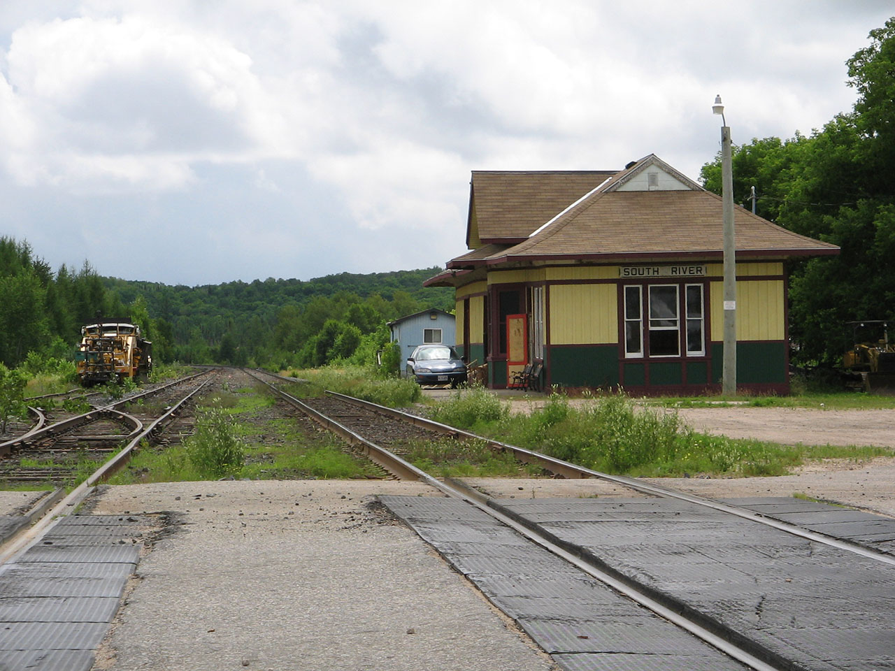 While on vacation in 2008, I did a day trip with a longtime friend. I had never been to South River before, and in my opinion, this was the first surprise out of that trip.

The South River station in midst of restoration, on a warm summer's day in July of 2008. This shot, looking southward, just took my breath away. Here, you start entering Northern Ontario. And what a view! Nothing but trees, sun, and clear skies.