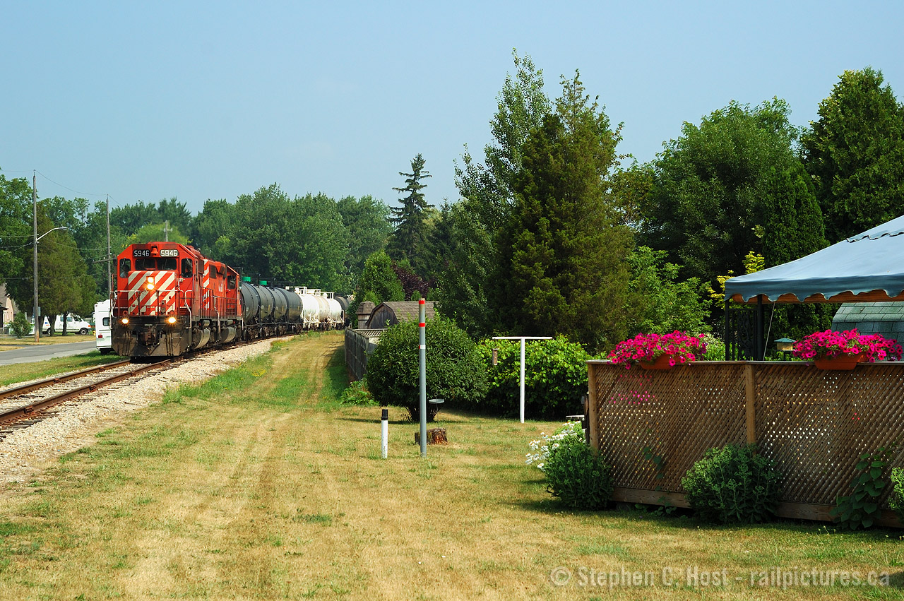 A backyard Railway in Chatham,  nearly five hours after departing Sarnia, D725 has arrived at what is "North Chatham" with 49 cars. North Chatham is the end of OCS limits and beginning of Yard limits, mile 19 Sarnia Subdivision and at this point, crews have to call the RTC to clear OCS limits and discuss with the Chatham Depot for their yarding instructions. 
And here's another audio clip - from precisely this moment pictured - as the train is passing me and I'm taking photos, the crew discusses with Chatham Depot yarding instructions, then calls the RTC to clear South Chatham. Click here for the audio