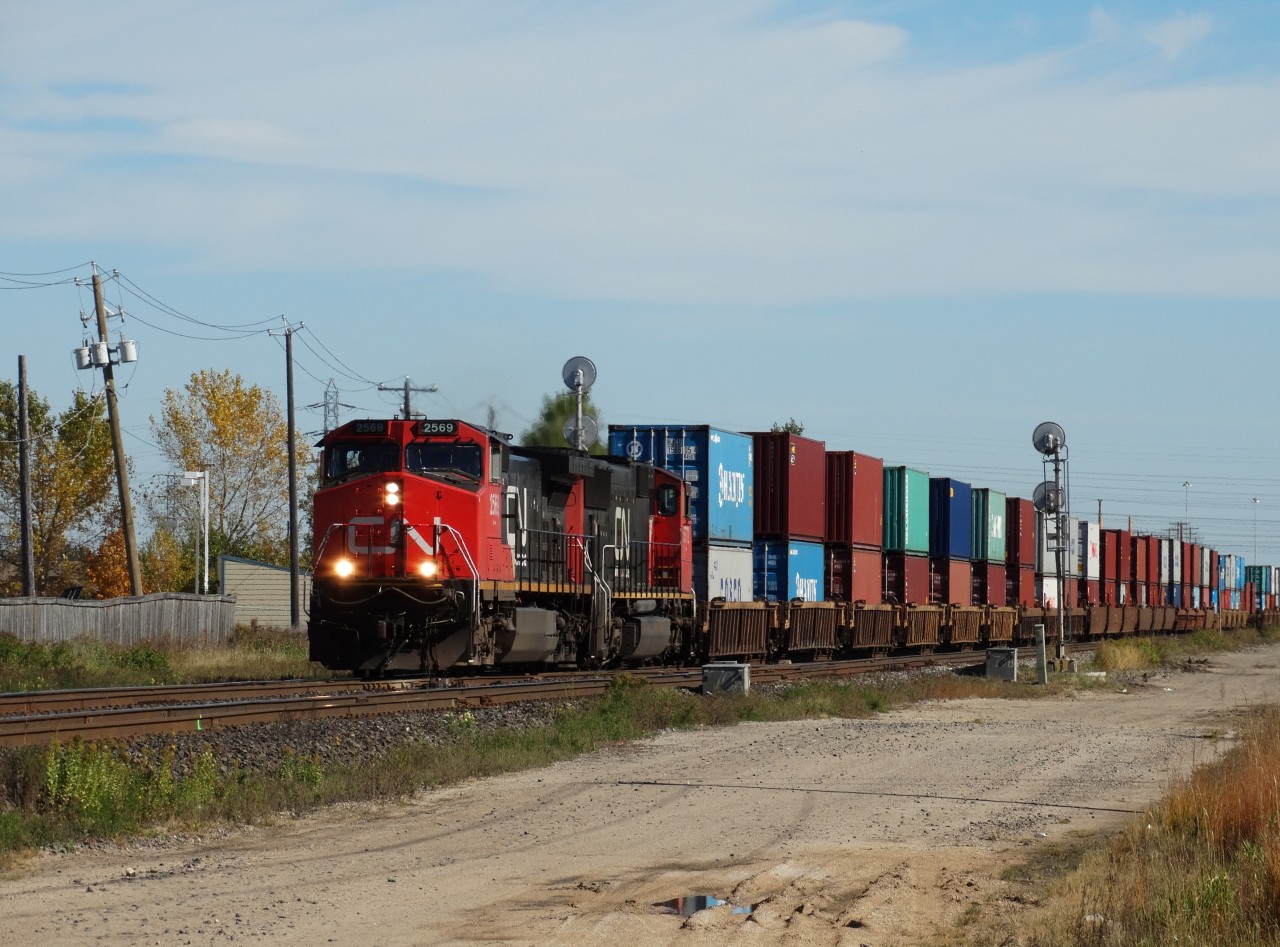 CN 2569 (C44-9W) and CN 5772 (SD75I) split the searchlight signals at Waverley Street in Winnipeg. The pair of six-axle units are working hard to pull a long Stack train west along the Rivers Subdivision.