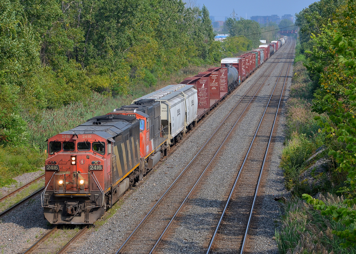 Zebra cowl leading. Zebra cowl CN 2416 & CN 5621 lead Montreal area transfer CN 527 towards nearby Taschereau Yard minutes after CN 401 passed.