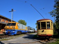 <b>A streetcar passing an LRC-3.</b> Streetcar MTC 1959 has just finished rounding the curve around Hays Station as VIA 6921 suns itself in front of the station. Behind it is coach CN 5064 and SW1200RS CN 1384.