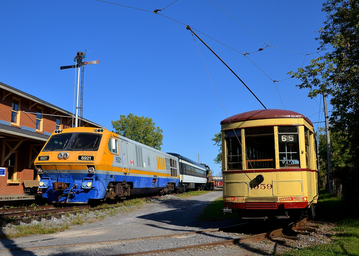 A streetcar passing an LRC-3. Streetcar MTC 1959 has just finished rounding the curve around Hays Station as VIA 6921 suns itself in front of the station. Behind it is coach CN 5064 and SW1200RS CN 1384.