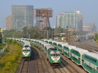 <b>A triple GO meet, with a shuttle approaching.</b> A GO Transit train is inbound, passing stopped trains on either side. In the distance UPX 1001 approaches with a shuttle from Pearson Airport.