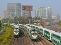<b>A triple GO meet, with a shuttle approaching.</b> A GO Transit train is inbound, passing stopped trains on either side. In the distance UPX 1001 approaches with a shuttle from Pearson Airport.
