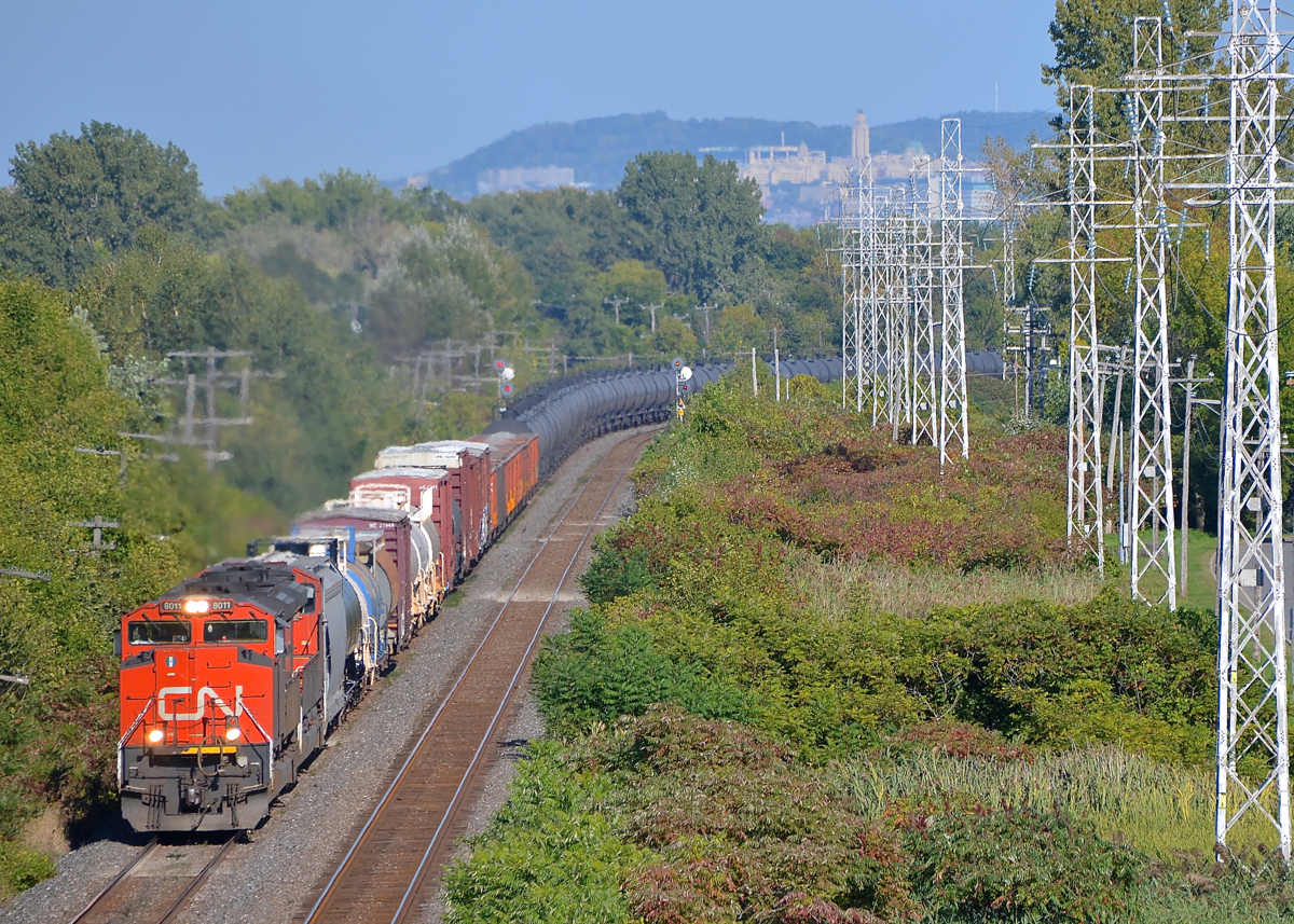 A high headlight SD70M-2 leading. One of CN's high headlight SD70M-2's (CN 8011) leads another, later SD70M-2 (CN 8926) as CN 377 rounds a curve in Pointe-Claire, with Mount-Royal in the background.