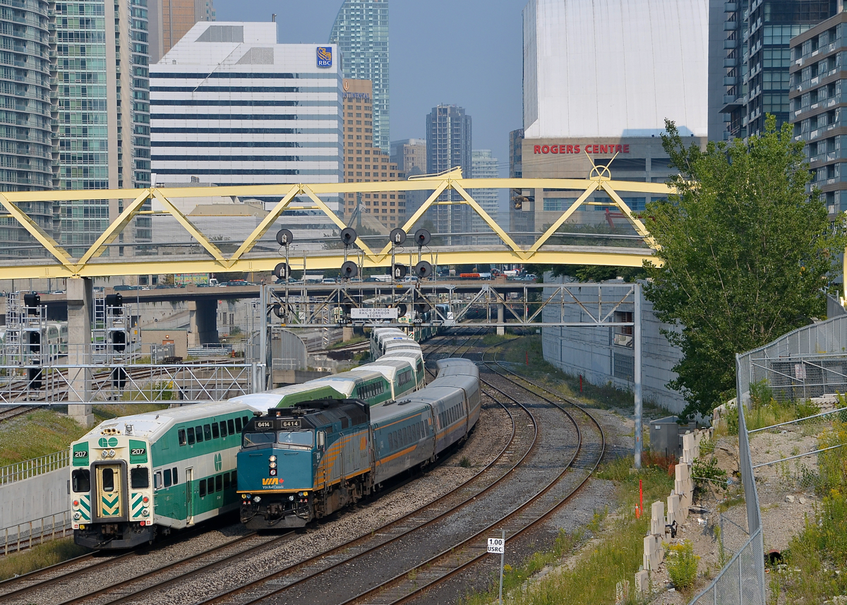 Past a stopped GO Transit train. VIA 6414 backs an LRC consist towards Union Station in Toronto, passing a stopped GO Transit train.