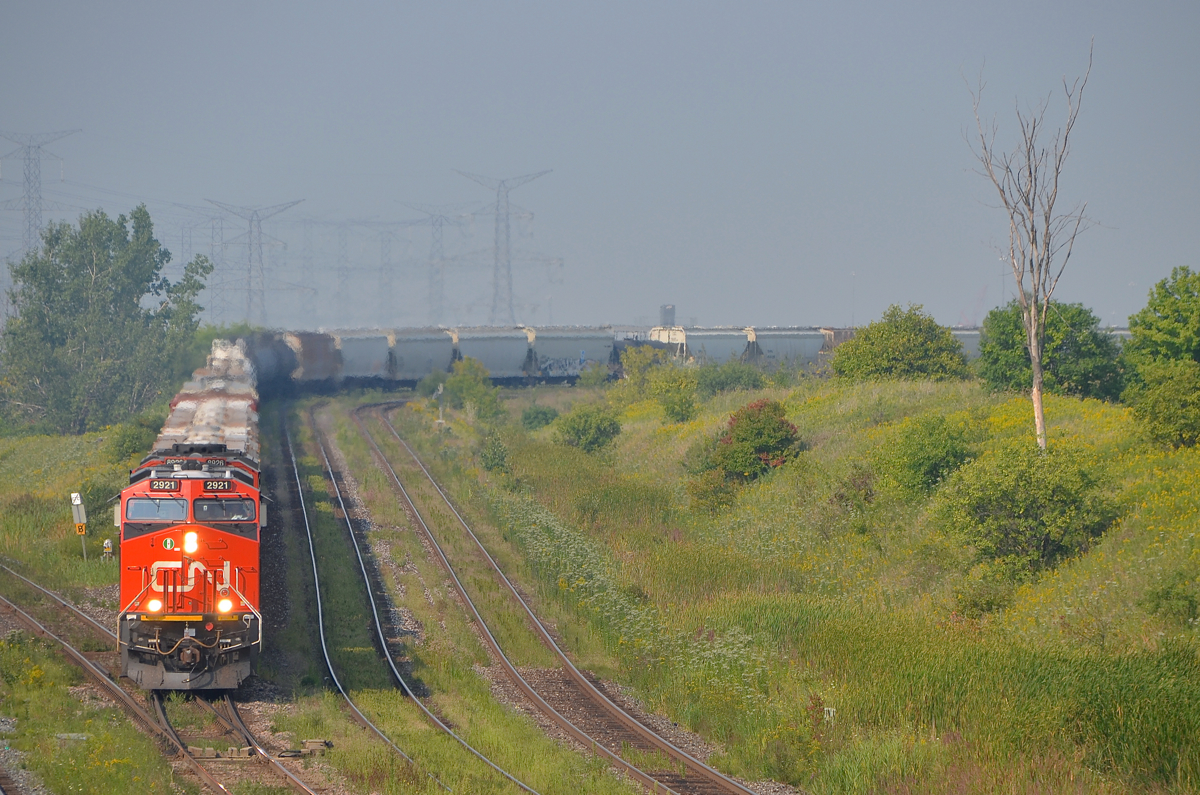 Dropping down out of MacMillan Yard. CN 376 is leaving MacMilan Yard and dropping down to the York Sub on a hot and sunny morning. Power is CN 2921 and CN 8926 at the head end and CN 2939 mid-train.