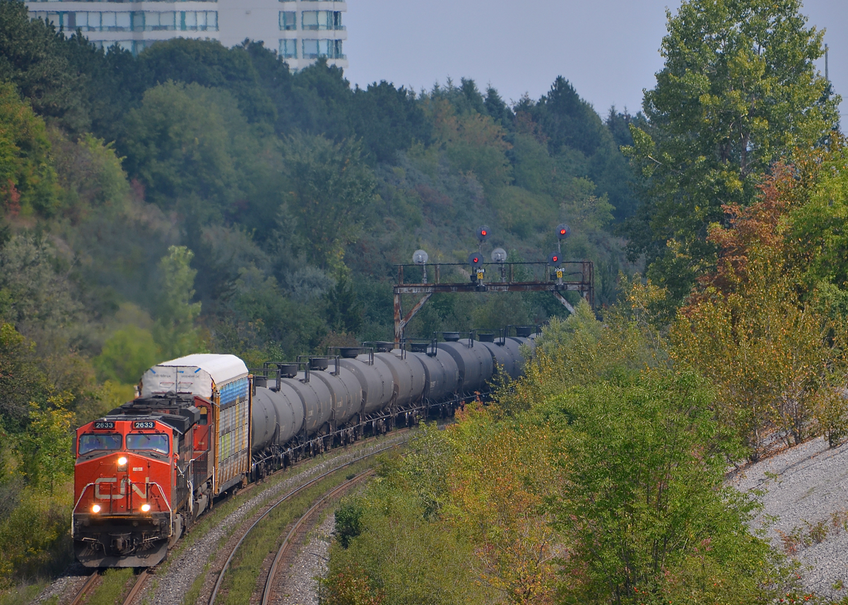 Climbing the York Sub. CN X318 with CN 2633 & CN 8856 passes the signals east of Hilda Avenue overpass. While this is an eastbound train, it is geographically westbound at this point, as it takes the York Sub to get from the Bala Sub to MacMillan Yard.