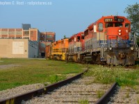 <b>Switching Airboss</b> in Kitchener, the hogger is gingerly guiding his train on track rated for 5 MPH maximum speed. Lifting one car out of the plant door, the hopper is likely an idler. There wasn't a heck of a lot of sunlight left by the time I found this scene..<br><br>This shot has taken quite a long time for me to achieve - seeing that Airboss is normally switched either first thing in the morning or late after dark and the light is only good late in the evening. What's neat about this location? The ancient factory - built in 1913 - formerly the <a href=https://en.wikipedia.org/wiki/Dominion_Tire_Plant target=_blank> Dominion Tire Plant (click for more) </a>it hasn't really changed much since then. -This is probably one of the oldest factories still receiving somewhat continuous rail service in this area - and to make it even more dramatic -  and this plant is very close to condo development where similar factories have been converted over and continue to be.<br>Secondly, this plant would have had electric overhead wire for the motors of the Grand River Railway (thusly the CP Waterloo sub). While the electric overhead was removed in 1961 when the GRR dieselised, CP continued to serve this plant until 25 July 1991 (Last move - thanks to George Roth for the info) and the spur in the foreground is the track that led to CP.<br><br>And one tidbit we locals know - back in 2005 when EMD was going gangbusters pumping out new CSX, UP, and BNSF SD70ACe's the facility behind me where this spur leads to was used to finish SD70Ace's for EMD - never did catch an engine going in or out of here, from what I recall the moves were done very 'hush hush' or in darkness at the time. A little known fact, mind you.. <br><br>What old factory do you wish you could see a railcar coming in or out of that still has a chance of happening?
