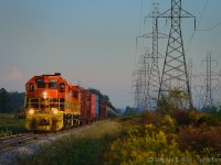 <b>A beach day</b> for me and my family - twice a year I visit Port Dover, and twice a year I have a chance of some SOR action down by Nanticoke - I don't always get lucky, but this was my lucky break as 4057 finally dissapeared from the Nanticoke job leaving just GW Orange. However, it's all in the timing - by the time I get everyone fed and  skin sufficiently tanned, where will 595 end up? I found them out on the road, which is awfully lucky, usually they are parked at the yard by this time<br><br>In this scene, 595 is heading TT west (north) on the rolling profile of the Hagersville sub, in the background are the codeline and a smokestack from the now idled Nanticoke Genrating Station, and the farmers fields of Haldimand county, all of which is lit by the last rays of the hot summer sun sometime after 7 PM.<br><br>As the train went by, the hogger gave us an extra toot of the horn - to the delight of my 5 year old. She put me up to this photo by asking me if we could  "see it again" after running into them the first time on the way home. She was delighted, as was I to oblige - with tummys full of beach food, our next destination was Hewwitt's dairy for for a malted milkshake, vanilla. A great day indeed. Thanks to the SOR crew for the extra toots of the horn and for making a little girl (and her boyish adult father) happy :)