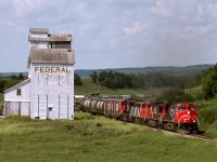 Eastbound CN freight 452 passes the derelict elevator at Runnymede as it climbs out of the Assiniboine Valley east of Kamsack on the Prairie North Line.