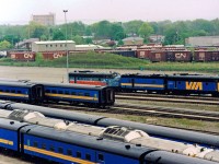 VIA FP9's #6530 & #6536 (in an unusual paint scheme) sandwiching a steam generator car at VIA's Toronto Maintenance Center. In the 1990's the Federal Conservatives enacted a round of draconian funding cuts resulting in a massive reduction of VIA Rail services (and retirement of first generation power). History would repeat itself 2 decades later with another round of cuts under the current Conservative government. Note the large number of CN boxcars in the background, and former CN steam heated passenger cars (including a combine) & RDC's in the foreground. For more pics & videos from my collection see my website at <a href="http://northamericabyrail.info"> http://northamericabyrail.info </a> , Cheers, Pete