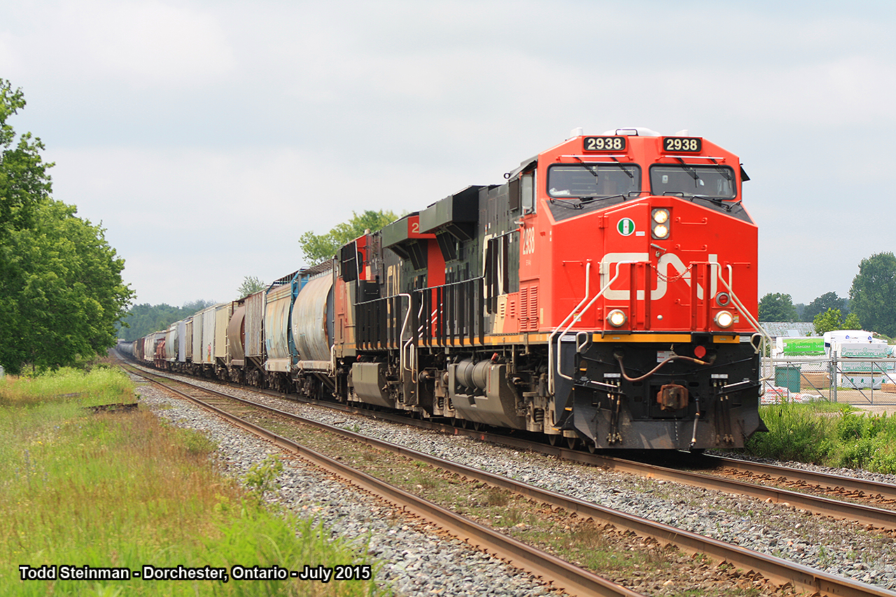 HAPPY CANADA DAY!  Lead CN engine 2938 (with CN 2837) pull this large mixed freight eastbound approaching the Railway Street crossing. In the background is Lind Lumber Yard, which has through the years overtaken the old Dorchester station site.