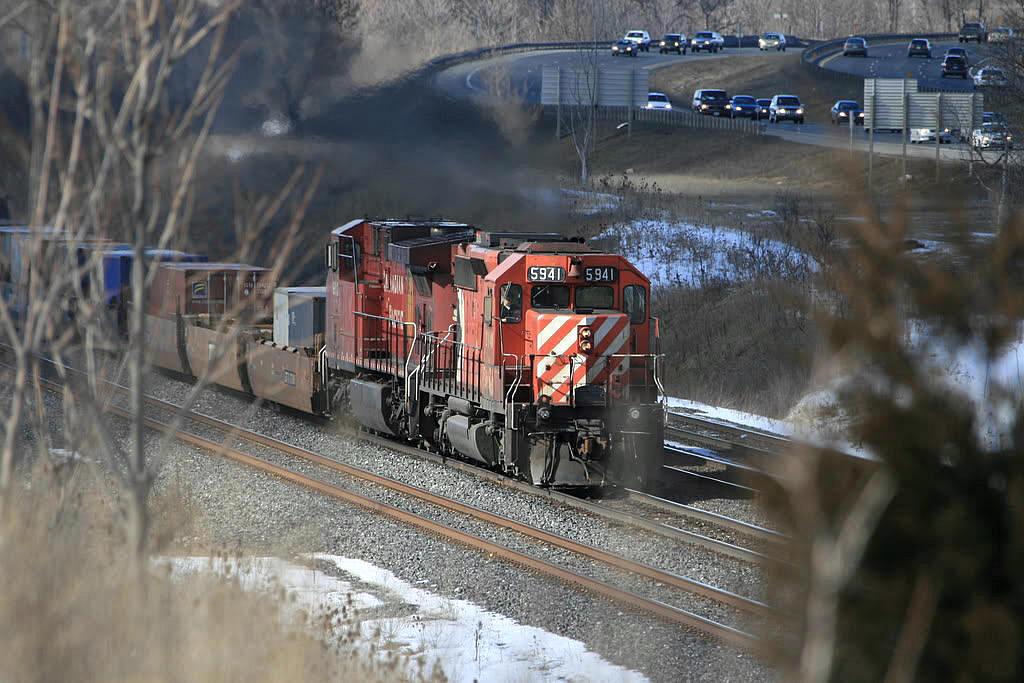 With a little over a year to go before the CP trackage rights on the CN Oakville Sub came to an end...CP 255 is barely off CP trackage when the ditch lights dimmed and he slowed to a stop at Waterdown. Shot from atop the "berm" with Hwy 403 in the background