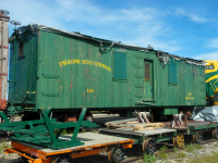 A very old boxcar/service car sits at the Prairie Dog Central yard. This wooden boxcar is slowly falling apart, with the paint coming off, and roof presumably collapsed.