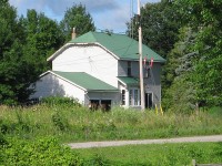The former Canadian National Coldwater station. It sits well back off of the old right of way (the ROW is in the foreground). Note the semaphore still attached to the station. It is still a private residence. Photo taken from River Street. 