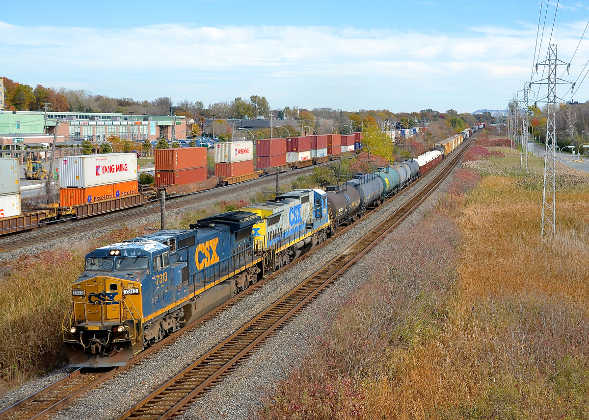Marker lights plated over. While many of CSXT's ex-Conrail Dash8-40CW's still have their marker lights visible in the nose (click here for an example), the marker lights on CSXT 7313 have been plated over. CSXT 7313 (ex-CR 6084) looks rather worse for wear as it leads CN 327 with a standard cab Dash8 trailing (CSXT 7538) through Pointe-Claire on CN's Kingston sub. At left CP 112 is eastbound on the parallel CP Vaudreuil sub.