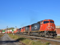 <b>Not an AC unit in sight.</b> CN 120 has often had solid AC lashups composed of ES44AC's and/or ET44AC's recently, but not this morning. On a sunny morning (with the moon visible) CN 120 rounds a curve in the St-Henri neighbourhood of Montreal with four DC units (CN 5789, CN 2686, CN 2246 & CN 2600).
