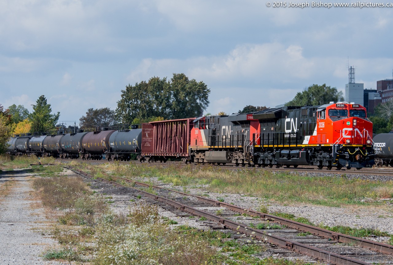 Delivered to CN at Fort Erie on September 29, 2015 CN 3036 a brand new ET44AC leads train 394 downgrade into Brantford during a brief period of sun.  I'm not the biggest fan of GEVO's but a nice and shiny one on the point sure looked good today!