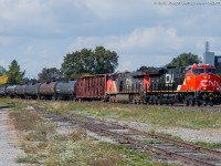 Delivered to CN at Fort Erie on September 29, 2015 CN 3036 a brand new ET44AC leads train 394 downgrade into Brantford during a brief period of sun.  I'm not the biggest fan of GEVO's but a nice and shiny one on the point sure looked good today!