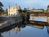 <b>VIA 902, reflected.</b> A late VIA 69 deadheads to Montreal's Central Station with VIA 915 and VIA 902 pushing as it passes the Wellington Tower.
