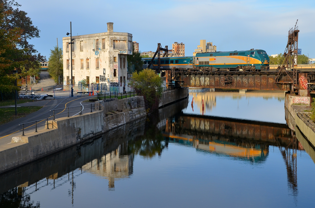 VIA 902, reflected. A late VIA 69 deadheads to Montreal's Central Station with VIA 915 and VIA 902 pushing as it passes the Wellington Tower.