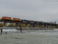 <b>Gone Fishin'</b>  As a pair of fishermen look on as RLHH 595 slowly crosses the Grand River in Caledonia with RLHH 3403, RLHH 3404 and 15 tank cars.