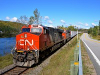 <b>Between the river and the road.</b> CN 369 is boxed in by the Batiscan river at left and Route 367 at right as it heads towards Garneau Yard in nothern Quebec. Power is 4 AC units: CN 2898 & CN 2949, along with CN 2854 & CN 3000 mid-train.
