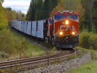<b>Dropping downhill.</b> The up and down nature of the CN Lac St-Jean sub is graphically illustrated by CN 369 dropping downgrade before curving towards a crossing. Power is 4 AC units: CN 2898 & CN 2949, along with CN 2854 & CN 3000 mid-train.