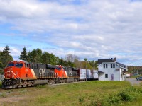 <b>Past Hervey Jct station.</b> CN 369 is passing the Hervey Jct station on its way to Garneau yard. Cars are parked in the parking lot, awaiting the arrival of the combined VIA 601 & 603 which will arrive in about half an hour before splitting up here. Power is 4 AC units: CN 2898 & CN 2949, along with CN 2854 & CN 3000 mid-train.