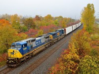 <b>Fall colours and snow.</b> CN 327 has a pair of ex-Conrail Dash8-40CW's in two paint schemes as it heads west through Beaconsfield with an even 400 axles. Fall colours are still present, but so was some snow.... though the sun would shine brightly ten minutes later on a topsy-turvy day for the weather in Montreal.