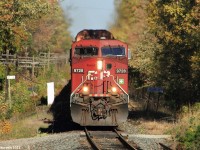 Westbound autorack train #147 whistles for a private crossing in Mountsberg Reservoir, just west of Guelph Junction with the Hamilton Subdivision at mile 41 of the Galt Subdivision. Today's 147 has an ES44AC leading an ex-SOO Line SD60 as they fly through Mountsberg.