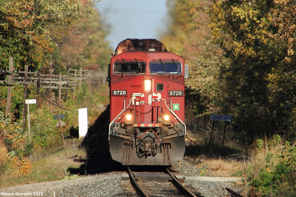 Westbound autorack train #147 whistles for a private crossing in Mountsberg Reservoir, just west of Guelph Junction with the Hamilton Subdivision at mile 41 of the Galt Subdivision. Today's 147 has an ES44AC leading an ex-SOO Line SD60 as they fly through Mountsberg.