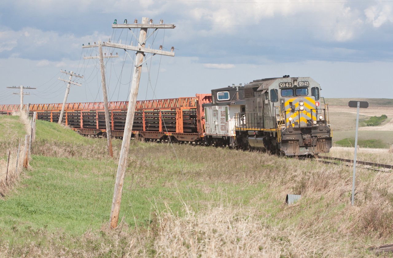 Drumheller Sub rail removal train on a gloomy day. Loaded train will drop the caboose at Dinosaur Junction, then continue to Drumheller for the night. The following day will go to Calgary, drop off full train, pick up empty and the process continued..