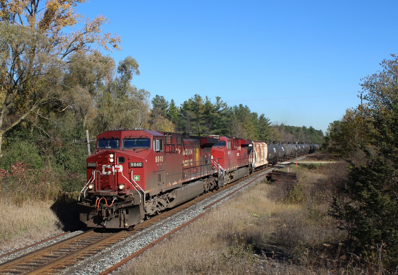 After coming up from Hamilton, CP 9840 leads CP 8919 over side road 20 in Puslinch with its load of empty ethanol cars. New rails and rail plates are already in place for replacement in the near future. Two of the few remaining old tie piles are still here as crews work their way down the Galt sub removing them.