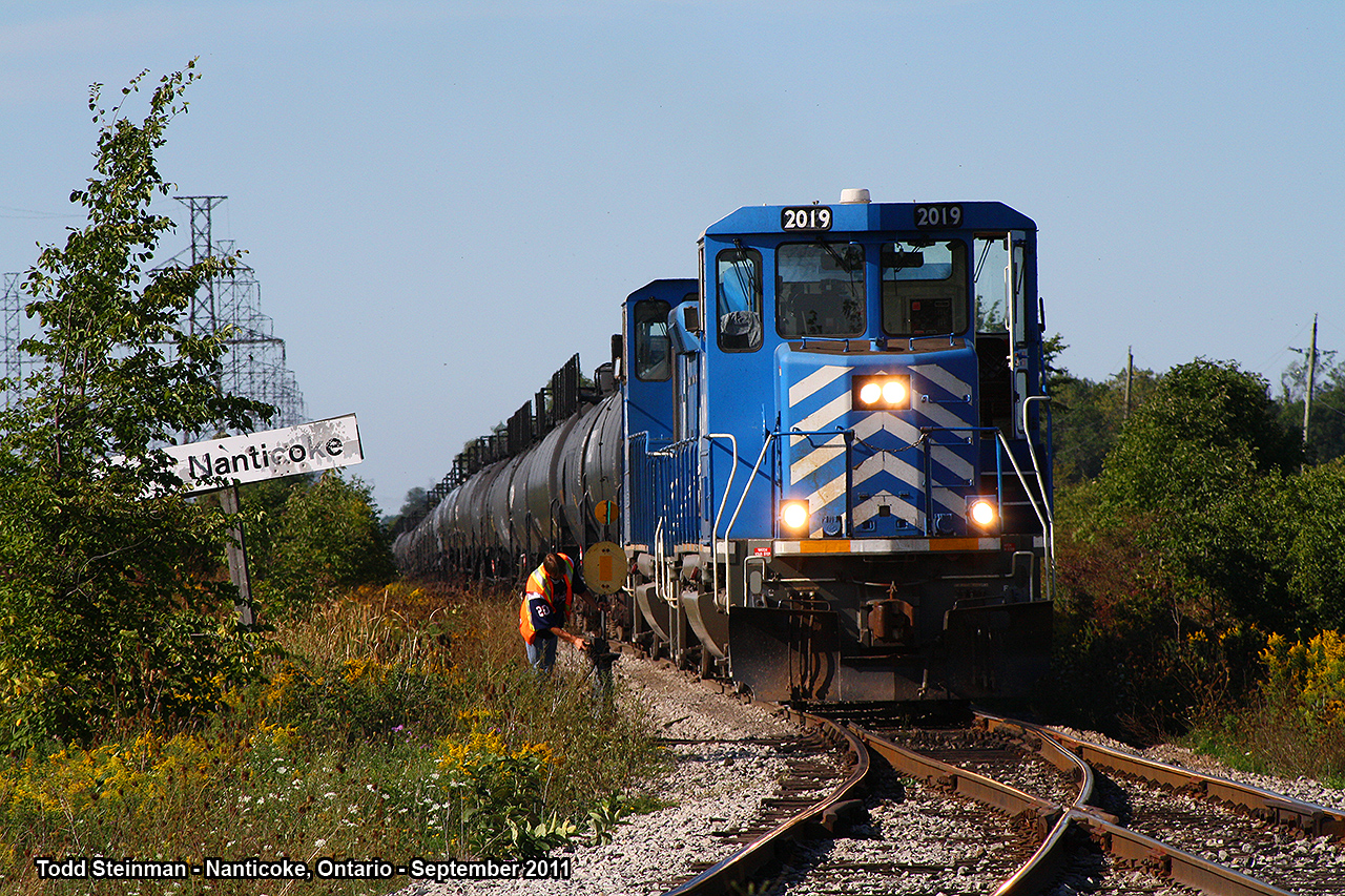 These are the weirdest engines I have ever set my eyes on. CEFX 2019 and 2014 lead this long consist of tanker cars bound for the Imperial Oil facility and Ontario Power Generating Station at Nanticoke. I was lucky this day in chasing a local train on the Southern Ontario Railway as it stopped just on the outskirts of the Imperial Oil facility. As I took this photo, the conductor had hopped out to unlock the switch - which they would use on the return trip from OPG to unload some tanker cars off on the storage yard just to the west. However, I still couldn't figure out why this train stopped at the name sign. Approximately half an hour later, a change in crew had arrived and the train proceeded to OPG.
