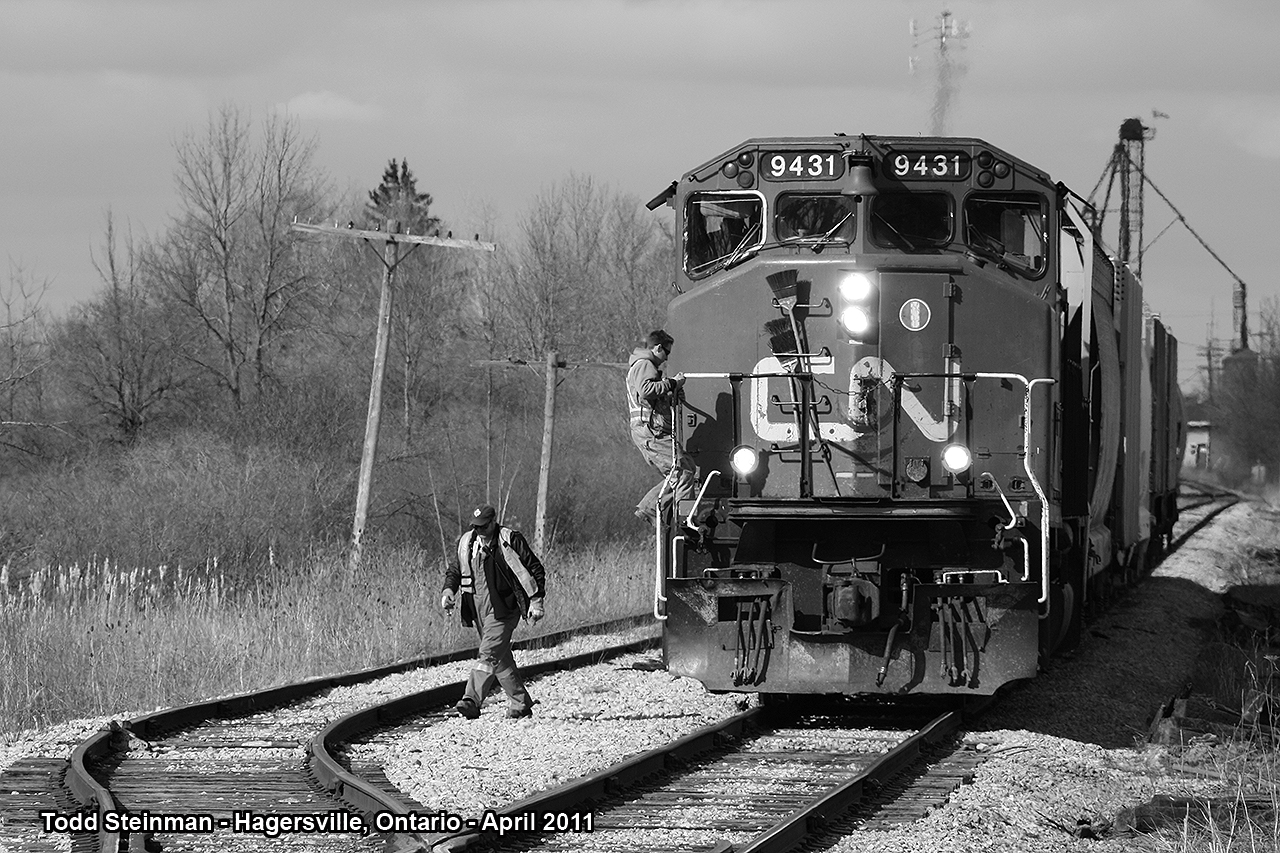 On this sunny day, I dang near killed myself trying to photograph this surprise. Ex-CN, now RMPX 9431 (now part of the Southern Ontario Railway fleet), pulled a short six car mixed freight south through Hagersville. I first caught glimpse of this freight on 1st Line, pulling out from a gas station. I was so excited when I grabbed my camera, that I forgot to pay attention to traffic and almost veered completely into the opposing lane. After re-composing myself and following this train to the south end of town, I caught both conductors disembarking the locomotive at the County Road 9 crossing. They were preparing to drop the six mixed cars into the siding.
