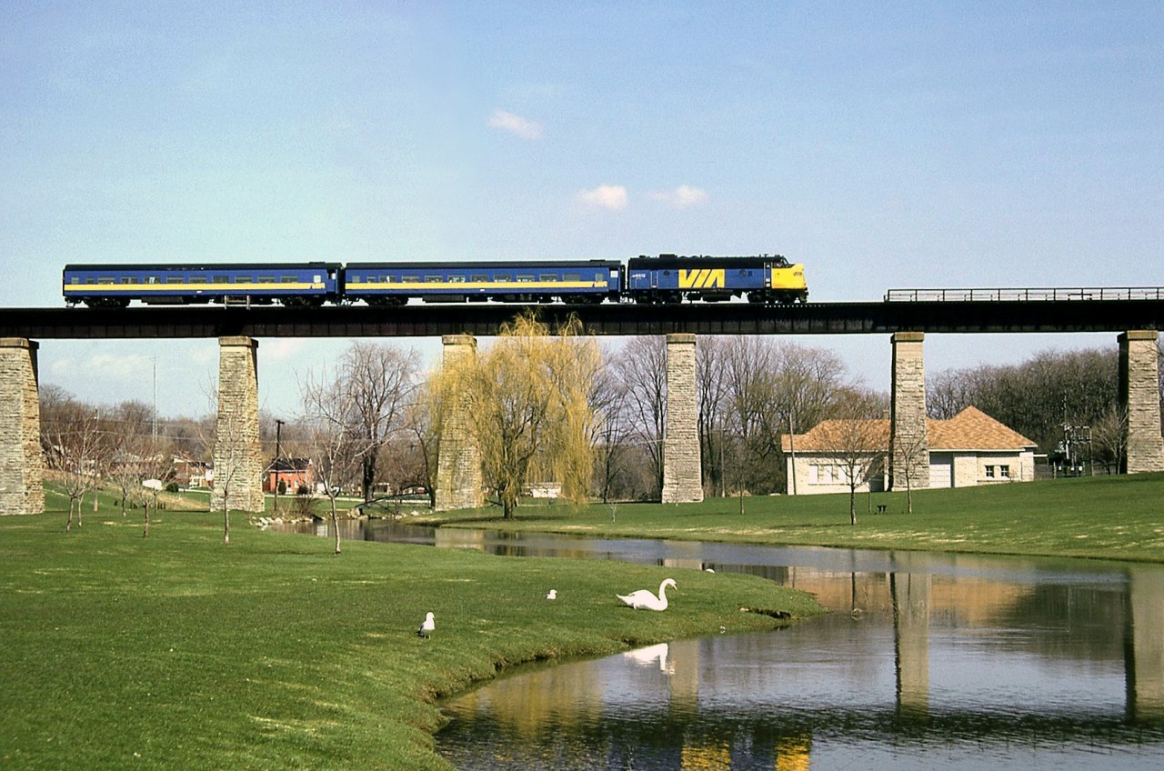 VIA #83 with an FP9 leading two classic blue-and-yellow ex-CN cars crosses the high bridge over Trout Creek, at St. Marys ON on the CN Guelph Sub (former Thorndale Sub from Stratford to London).