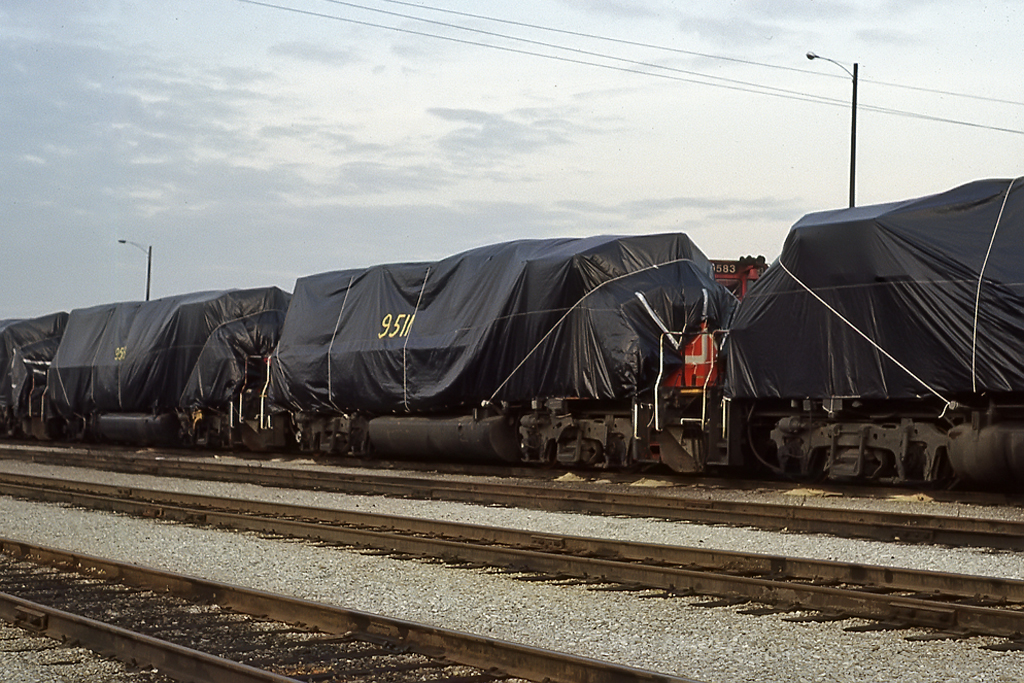 Probably the worst thing to see the day you achieve your "life long dream"of being hired by CN. 30+ GP40-2's under tarps stored because of low traffic.