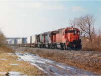 For a brief spell in the late 1980's GTW, which was now part of the CN empire; ran what was dubbed "The Laser", a daily TOFC (trailer on flat car) train; I believe Detroit to Toronto/Montreal, and I am not even sure of the train number: I recall 231/232 but would appreciate corrections.  The GT had taken over the DT&I (Detroit, Toledo & Ironton) back in 1983 and their power was intregrated into GTW, so it was possible to see one of their original paint units in service on the Laser. Here, we catch one on the lead as it rolls east thru Aldershot past the old Howard Rd extension that was a popular place for train nuts to hang out at that time. With a third rail going in a few years ago, this location became redundant and now is just a memory. Power is DT&I 6410, GT6408 and 6415. Note the DT&I has been renumbered into the GTW roster.  That is Lemonville Rd bridge in the background.