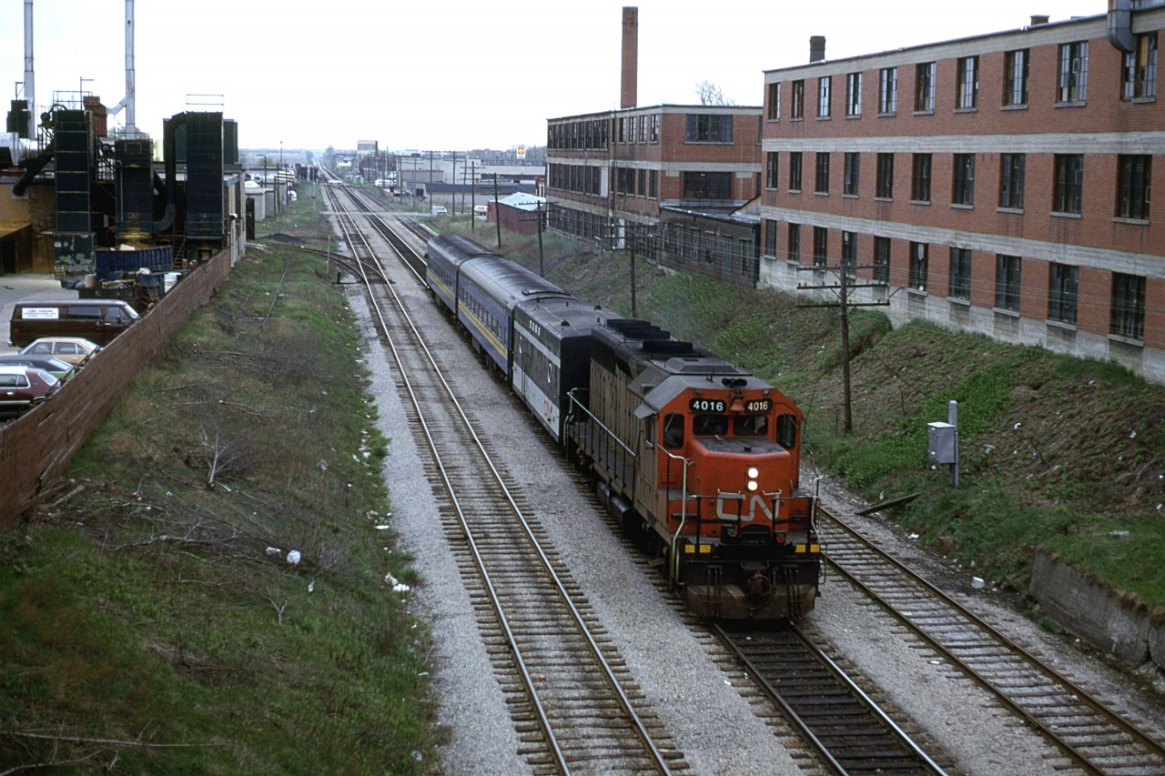 VIA #85 is just a couple hundred meters from Kitchener's Station, as it ducks under Margaret Ave.
factories line the ROW and CN's yard may be seen in the background.
If I recall, there used to be a very good pizza joint just to the right on Margaret Ave and Victoria St.