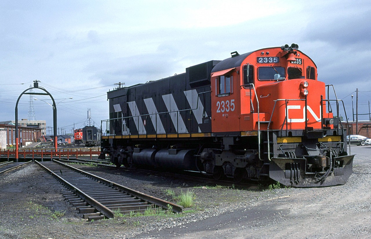 CN 2335 sits on one of the outside tracks around the turntable at Fairview. Blocked by the engine is the old coaling tower, but one of those your-mother-says-you're-ugly GP-40's can be seen.