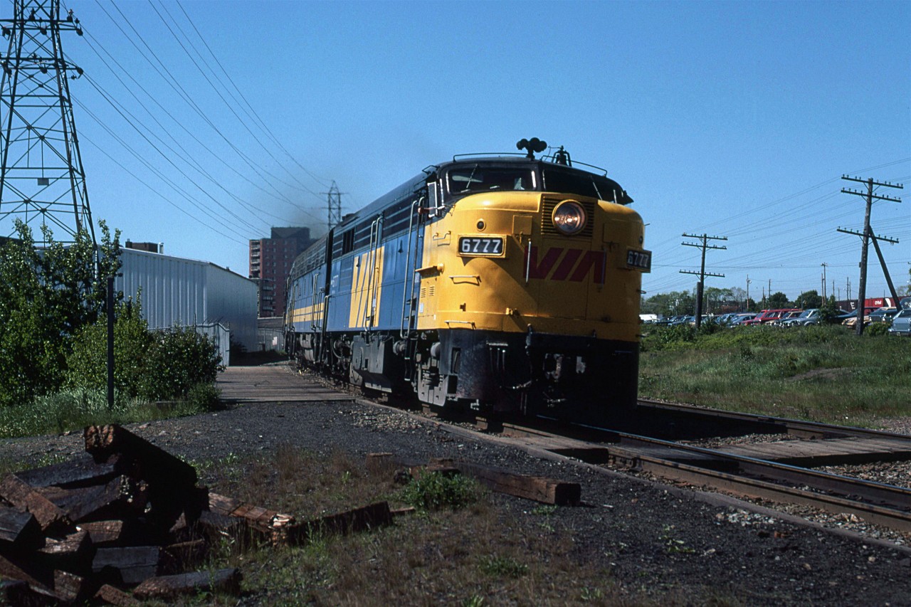 VIA's eastbound Atlantic is only a few minutes from the Halifax Terminal.
It is at Armdale, a flag stop for local VIA trains. 
Note the CPR boxcars at far right. These are at the Simpson-Sears warehouse and store. Shoppers from around Nova Scotia could come into town on the RDC's, walk to Simpson-Sears and the adjacent Halifax Shopping Center, then catch a return train home.